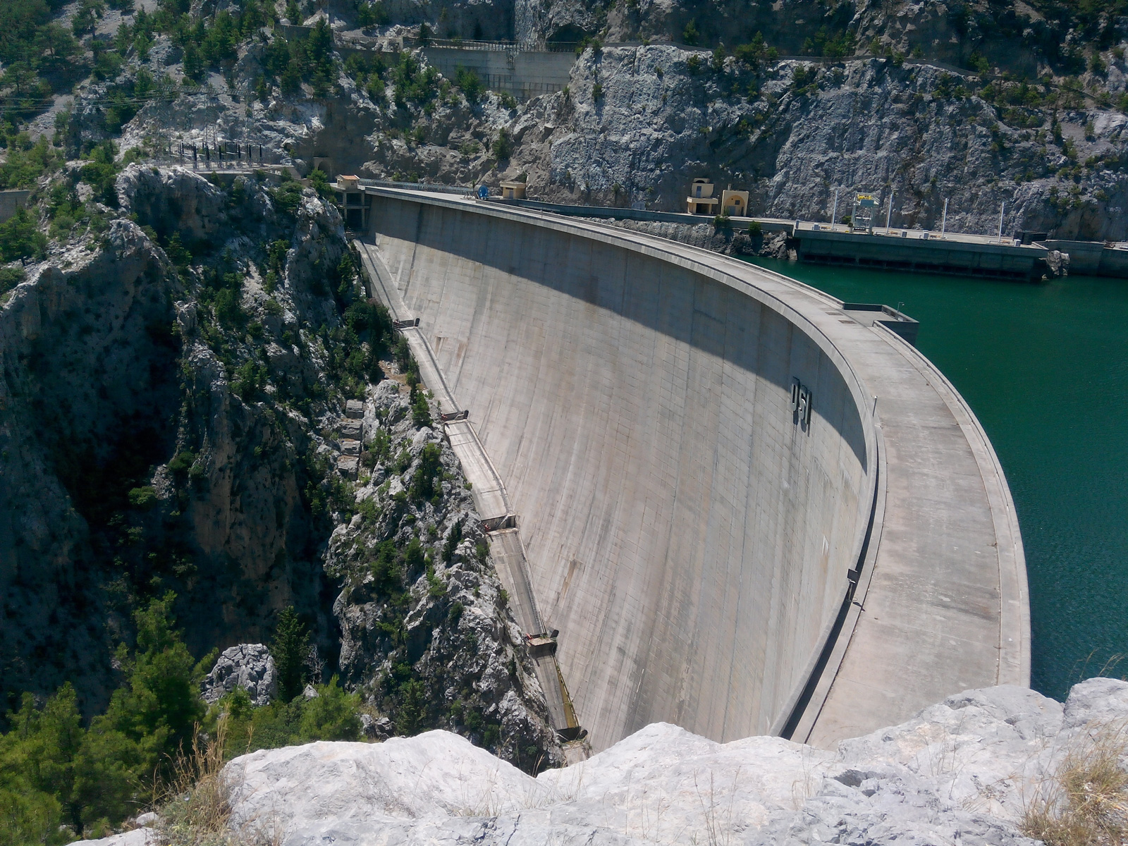 Man Using Measuring Tape in Factory Setting Man Using Measuring Tape in Factory Setting